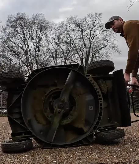 mower laying on its side to remove blades