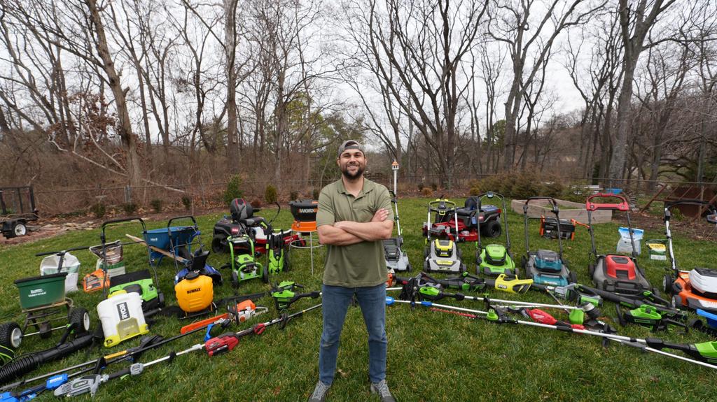 tyler with all of his lawn equipment in his yard